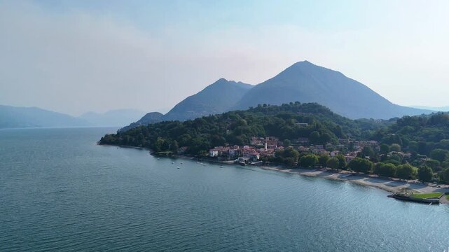 Aerial 4K drone video footage with panorama of Lake Maggiore, Italy, with majestic Alpine mountains surrounding the scenic lake, showcasing the breathtaking landscape of the Italian Lakes region