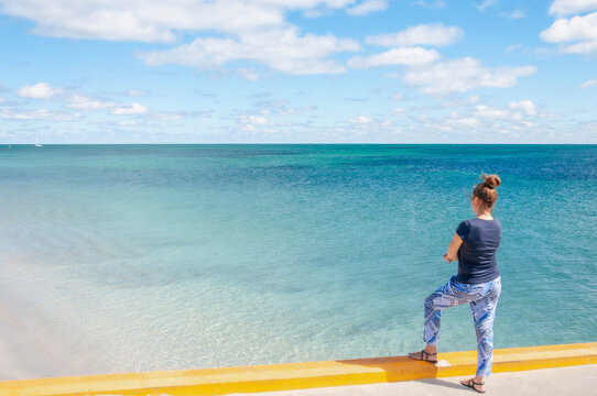 Coastal travel scene with a woman enjoying an expansive ocean view on a sunny day in Western Australia