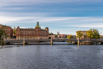 Naklejka premium Scenic panoramic view of historic European city with bridge crossing river under clear sky