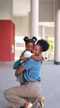 Young girl in a school uniform happily running towards her mother for a loving hug. Emotional reunion between parent and child after classes