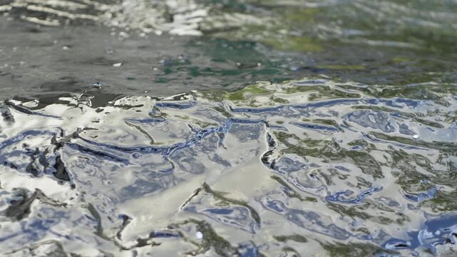 Surface is coated with bituminous waterproofing putty, creating shiny, black, and viscous layer. This putty is used to protect concrete surfaces in buildings from water infiltration