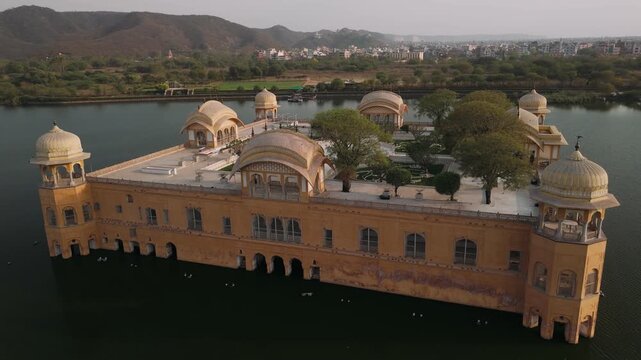 Aerial view of jal mahal water palace on man sagar lake in jaipur with cityscape and mountains in the background