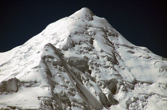 View of the snow-covered peak of Miar Chhish with glaciers and rugged mountain terrain in Nagar, Pakistan.
