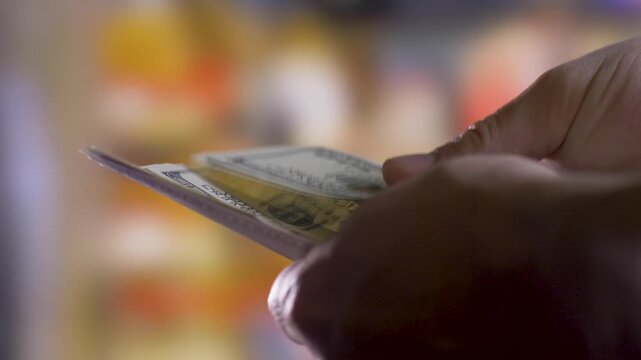 Person calculates 100 dollar cash in hands. Close up. Blurred background. Insurance concept