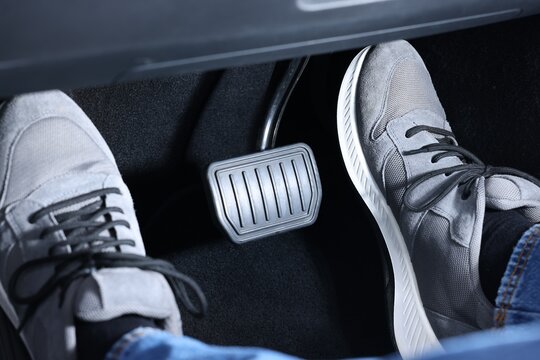 Man pushing accelerator pedal in car, closeup on foot