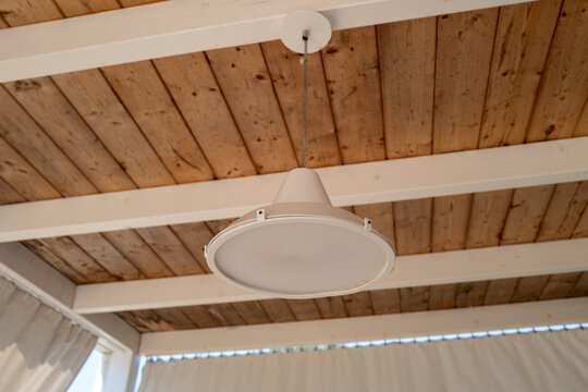 Minimalist light fixture against natural wood ceiling