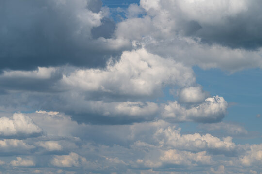 Expansive sky filled with layered white cumulus clouds over blue horizon