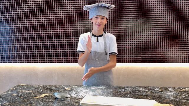 Young cook shakes off flour from hands &mdash; home kitchen, slow motion