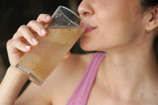 Unidentified fitness woman drinking a glass of water with psyllium husk to improve IBS symptoms
