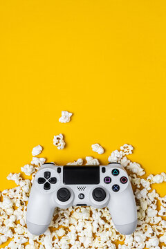 August 31, 2026, Odessa, Ukraine. White Sony PS4 DualShock controller with popcorn on bright yellow back