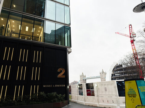 Business office frontage at 2 More London with Tower Bridge and construction crane in London, UK modern riverside architecture and corporate workspace
