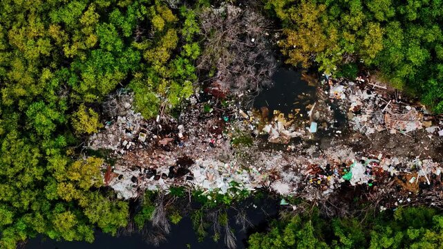 Aerial view of plastic waste and debris scattered in a lush green forest area near Gili Meno in Pemenang, West Nusa Tenggara, Indonesia.