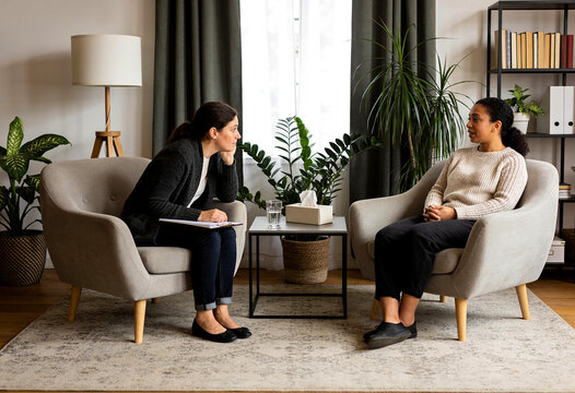 Counsellor and client talking during a therapy session in a warm room