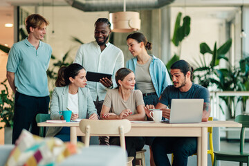 Obraz premium Diverse business team collaborating, young people brainstorming ideas and discussing project strategy in a modern office environment