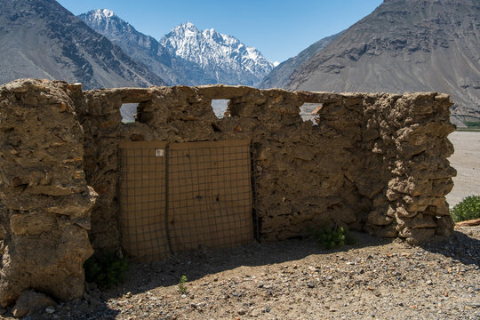 View of a stone structure with a mesh-covered opening in the Wakhan Corridor, set against snow-capped mountains in Badakhshan, Afghanistan.