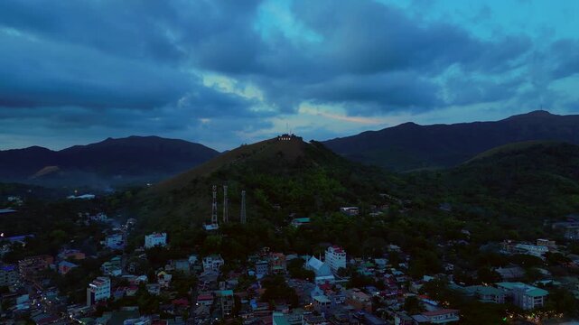 Illuminating Coron sign on Mount Tapyas with the town below, showcasing Palawan's popular travel destination at evening. Fabulous aerial view static hovering drone panorama