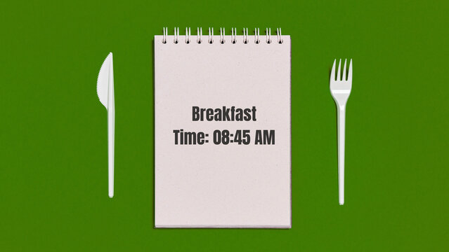White notebook showing breakfast time concept with plastic tableware