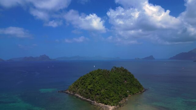 speed ramp time lapse Depeldet Island's lush green landmass connecting to a white sand beach and coastal, surrounded by clear blue waters. Dramatic aerial view fly reverse drone panorama