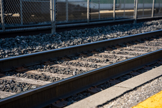 Close up of railway tracks beside a platform.