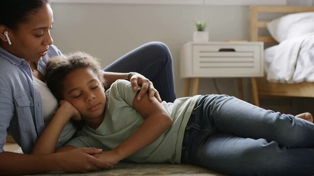 Noticing child resting, mother in blue shirt adjusting arm, stroking her on bedroom rug for comfort
