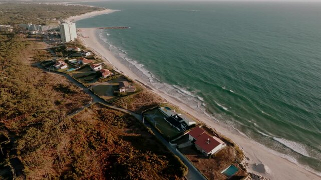 Aerial - Ofir coastline with beach houses pools pine woods and Atlantic waves in Portugal
