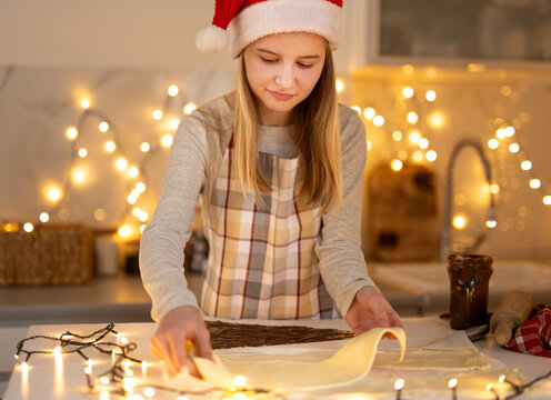 Teen Girl In A Santa Hat Making Christmas Cookies In The Kitchen