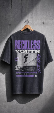 Black oversized graphic streetwear t-shirt with reckless youth print hanging on wall