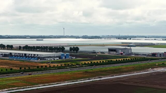 Aerial view of the extensive Agriport A7 greenhouse complex with surrounding agricultural fields and roads in Middenmeer, Noord-Holland, Netherlands.