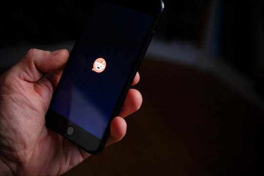 CLUJ-NAPOCA, ROMANIA - 24th FEBRUARY, 2025: A person is opening Reddit app on a phone
