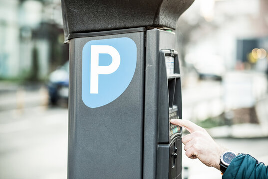 man paying parking ticket in the city