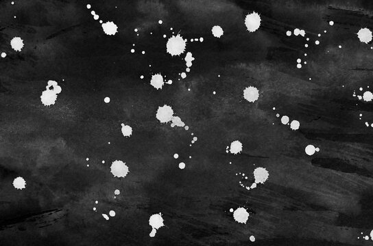 White ink dripping on paper isolated on a black
