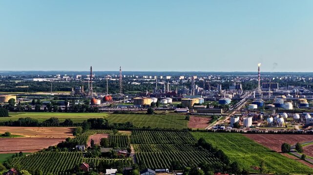 Aerial view of Orlen Plock Production Plant with industrial towers, storage tanks, and surrounding agricultural fields in Plock, Masovian Voivodeship, Poland.