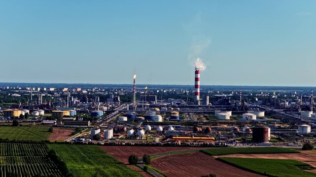 Aerial view of Orlen Plock Production Plant with industrial towers, storage tanks, and pipelines under a clear blue sky in Plock, Wojewodztwo mazowieckie, Poland.
