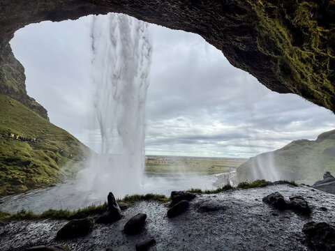 Seljalandsfoss Waterfall is an iconic attraction on the South Coast of Iceland. With a unique pathway that lets you walk behind the cascading water	