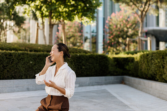 Korean woman enjoys a delightful conversation in a serene urban park