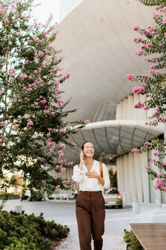 Korean woman enjoying a sunny day while walking through blooming flowers