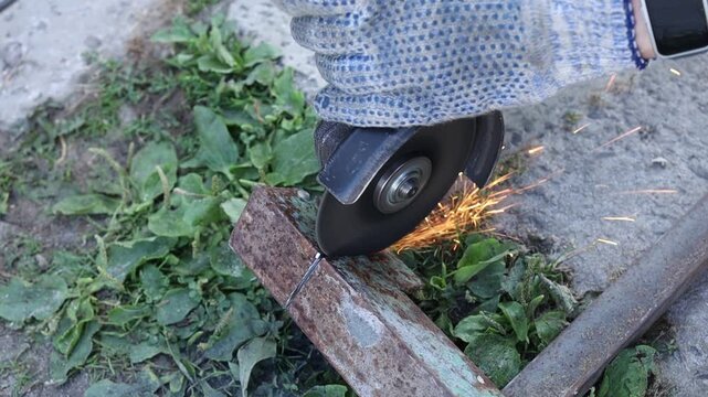 Cutting metal with a grinder outside in daylight