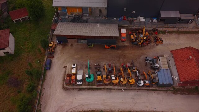 Aerial Top Down View of Heavy Construction Machinery and Excavators Parked at Industrial Depot