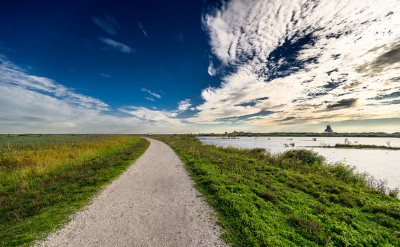 Beautiful sky and cloudscape over a footpath leading to the horizon at nature reserve Marker Wadden, The Netherlands.