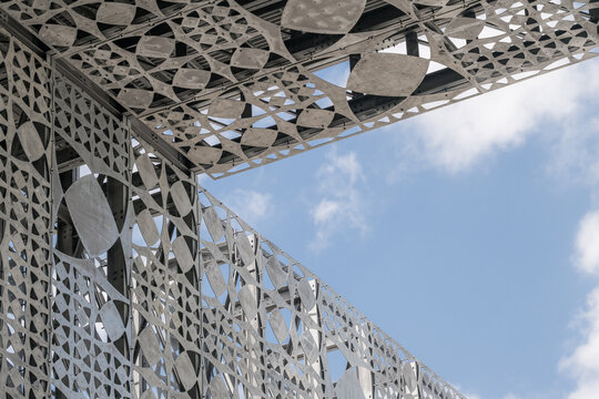 View of the intricate geometric metal facade of Tirana International Airport against a blue sky in Rinas, Albania.