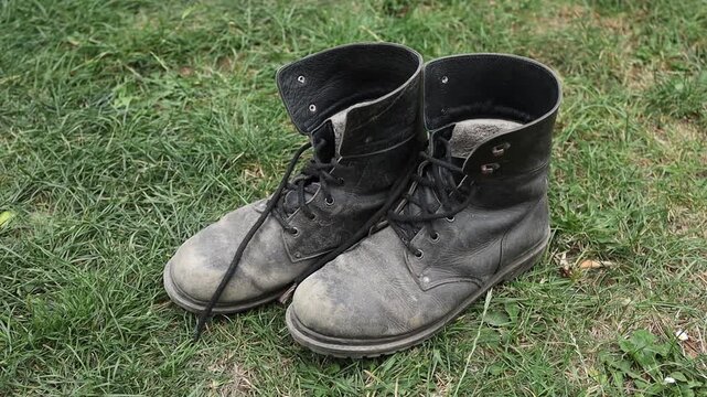 Old boots placed on green grass