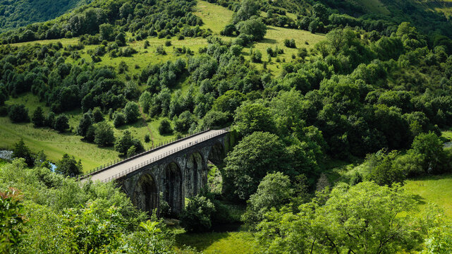 Panoramic view of Headstone Viaduct surrounded by dense green forest in Monsal Dale Peak District Derbyshire England