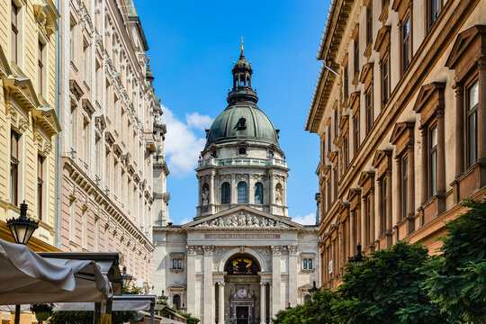 Symmetrical street view of St Stephen Basilica framed by grand classical city buildings in Budapest Hungary