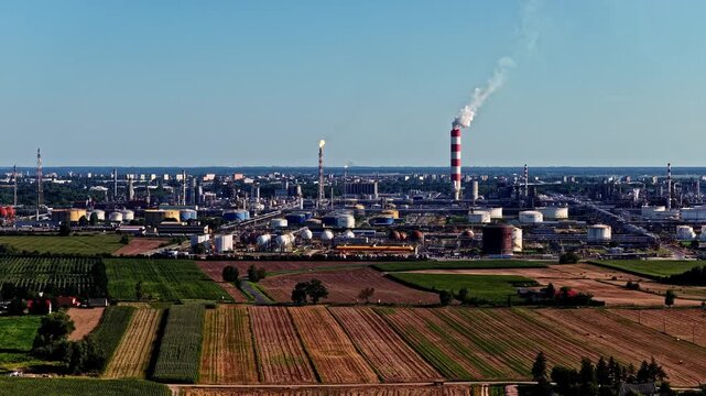 Aerial view of Orlen Plock Production Plant featuring industrial chimneys, storage tanks, and surrounding agricultural fields in Plock, Masovian Voivodeship, Poland.