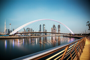 Fototapeta premium DUBAI, UAE - FEBRUARY 2018: Colorful sunset over Dubai Downtown skyscrapers and the newly built Tolerance bridge as viewed from the Dubai water canal.