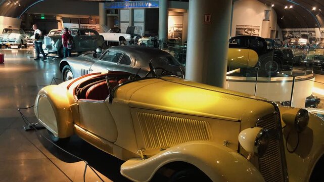 Showcase of rare vintage classic cars displayed in a museum hall featuring retro convertible sports vehicles, antique automobiles, and beautifully restored historical motor cars on luxury exhibition 