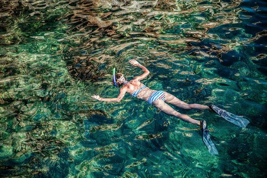 top view of woman snorkeling in clear waters