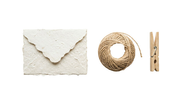 Textured handmade paper envelope with a rustic twine ball and small wooden peg arranged neatly on transparent background