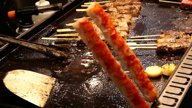 Japanese Teppanyaki Kushiyaki of grilling meat on griddle
