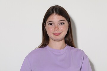 Fototapeta premium Beautiful teenage girl with freckles on white background